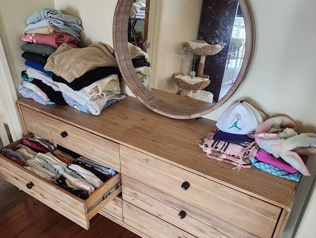 Neatly folded clothes on dresser with organized drawers