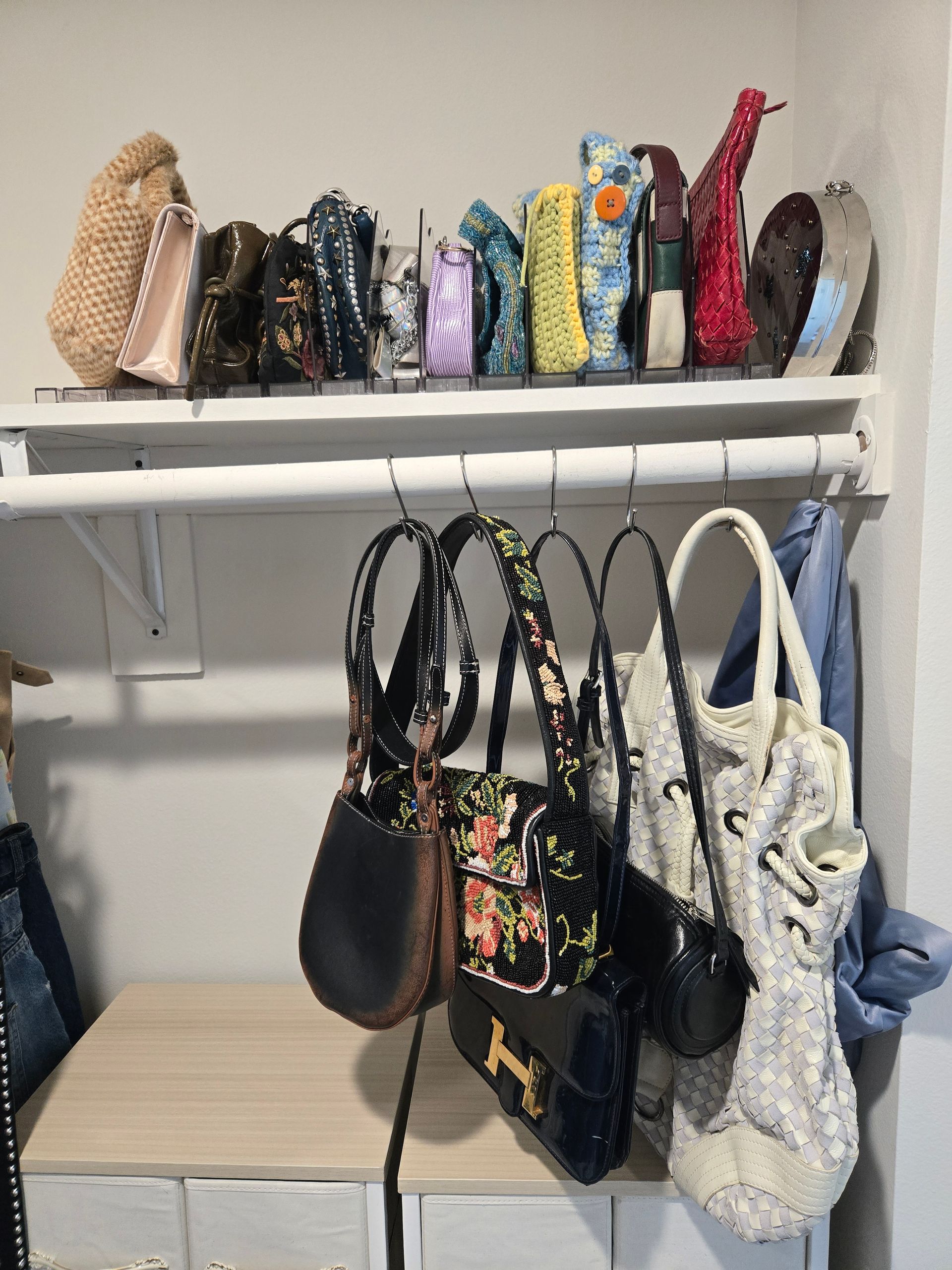 Organized handbag collection on shelf with hooks