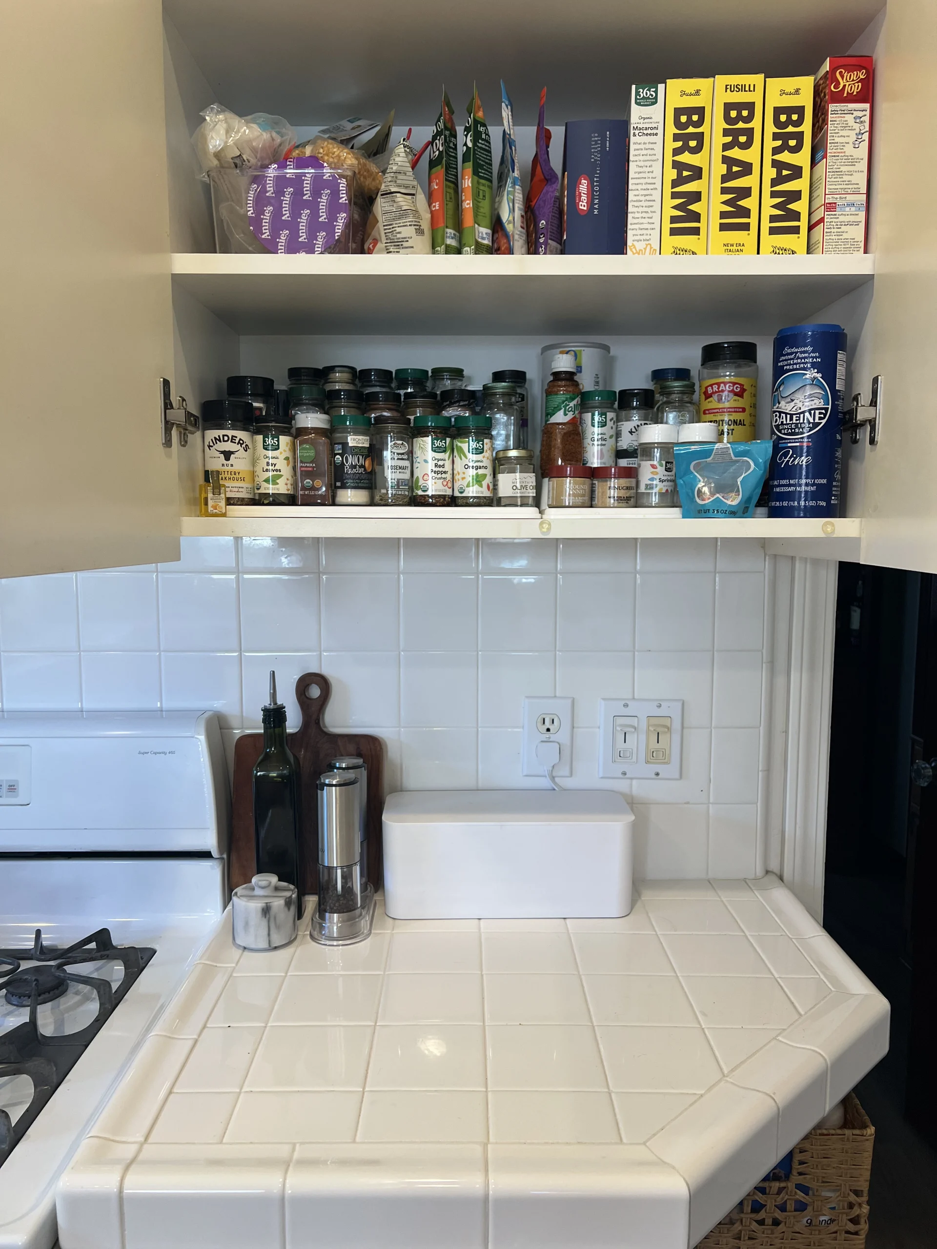 Organized kitchen shelves with spices, pantry items, and cutting boards